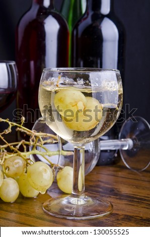 Two grapes fall into the white wine