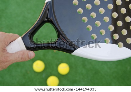 Paddle tennis racket, hand and balls