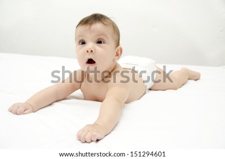 Lying baby on white bed.White bedroom.
