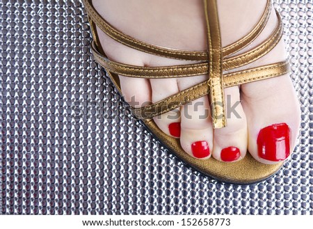 Closeup image of vintage shoe and red nails.
