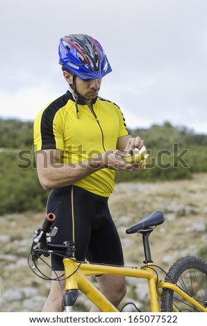 Mountain bike sport: cyclist eating banana looking for potassium
