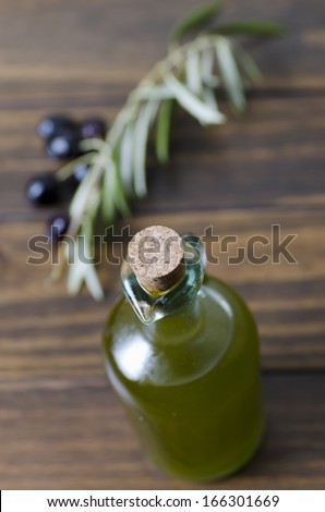 Focus on olive oil bottle cork and olives in background