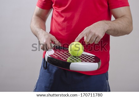 Closeup image of paddle tennis player with ball and racket