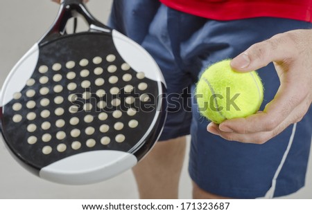 Paddle tennis player ready for serve in studio shot