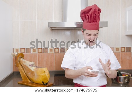 The chef in the kitchen. stressed with phone