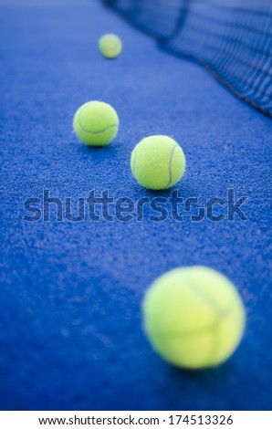 paddle tennis or tennis balls on artificial turf ready for tournament with hard dramatic shadows.