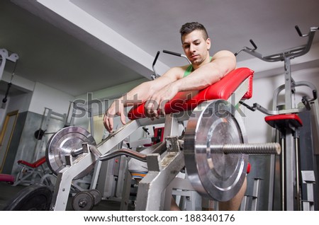 Young man in old gym ready for trainning his biceps