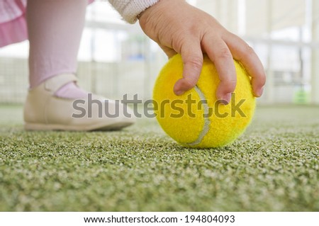 Image of baby catching tennis ball. Learning sport from birth.