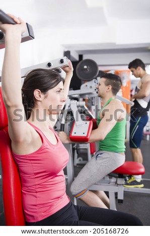 Gym friends doing some shoulder exercises at gym