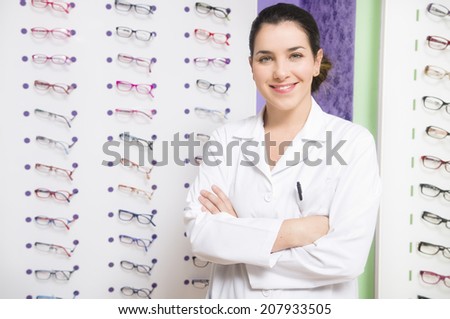 Optometis looking at the view in glasses store. Professional young worker woman.