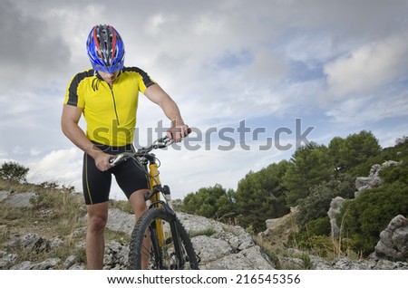 Mountain biker resting near to his bicycle