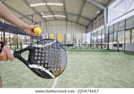 Paddle tennis serve at indoor court in wide angle image
