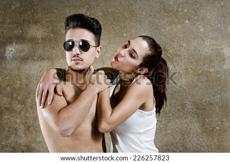 Man and woman posing in studio shot like young lovers. Woman is rejected or ignored.