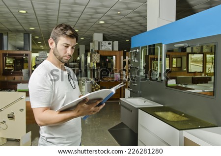 Man observes catalog in indoor wc and plumbing store