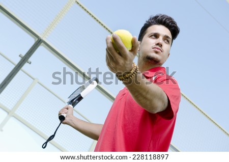 Man ready for paddle tennis serve in outdoors court