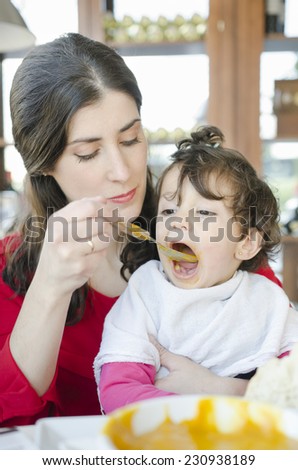 Cute baby eating food jar at restaurant