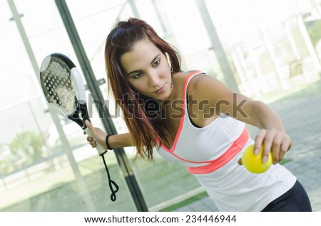 Attractive woman ready for paddle tennis serve