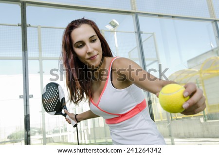 Woman ready for paddle tennis serve in real outdoors court