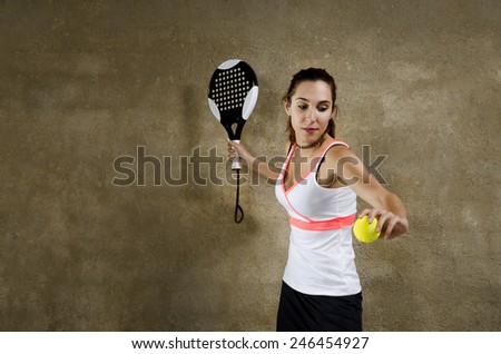 Paddle tennis woman player in concrete court ready for serve