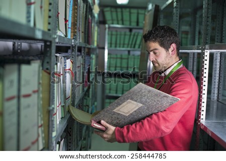 Young real office clerk working near to files