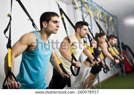 Young people training in elastic rope at fitness gym center