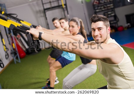 Group of people training elastic rope at gym in cross and fit room