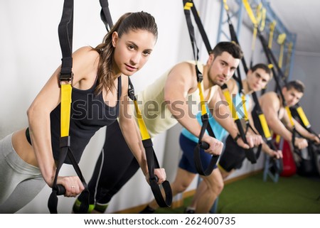 Group of people training in suspension elastic rope at gym and looking at the view