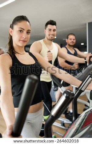 People training at cross trainer elliptical bike looking at the view