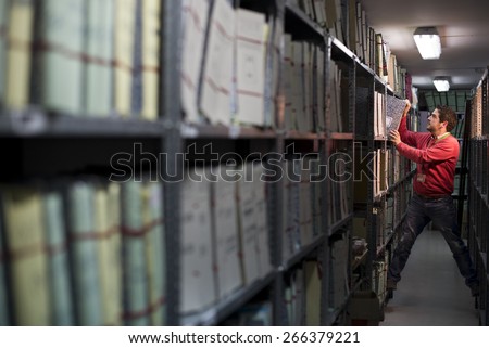 Files clerk working in basement looking for something paper or file