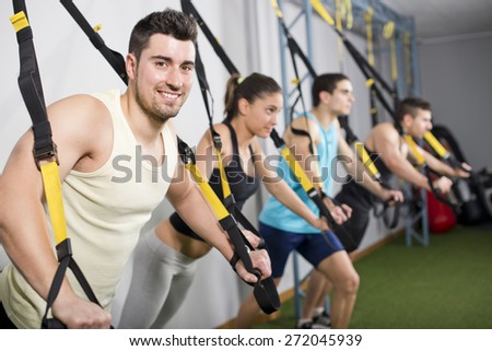 People at gym doing elastic rope exercises