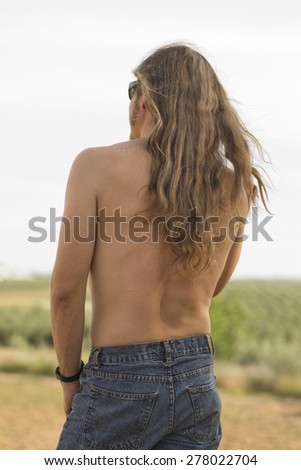 Attractive young blonde man with long hair without shirt