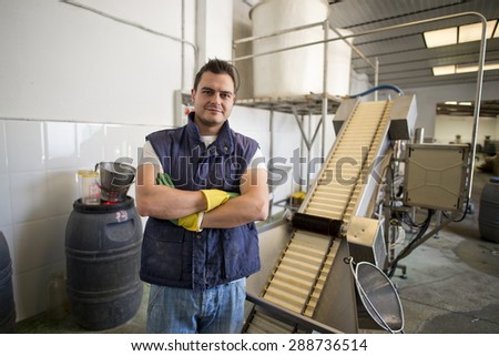 Worker posing in factory machine with ambient light
