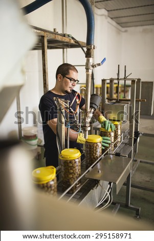 Candid photos of realistic man man working in olives factory