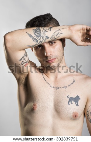 Young man with prison tattoos posing in studio shot
