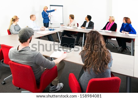 Several businesspeople meeting in a spaceous meeting room for a presentation