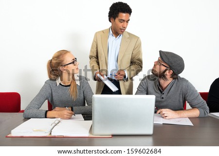 Two business people in the creative sector asking questions to a trainer during a refresher course workshop