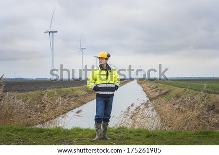 Project developer has ideas about the landscape he is standing in with a lot of windmills for green energy in the background.