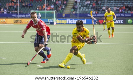 THE HAGUE, NETHERLANDS - JUNE 2 2014: Englishman Catlin reaches for the ball to stop a rush by Indian player Manpreet during the Hockey World Cup in the match between England and India. GBR beats IND 2-1