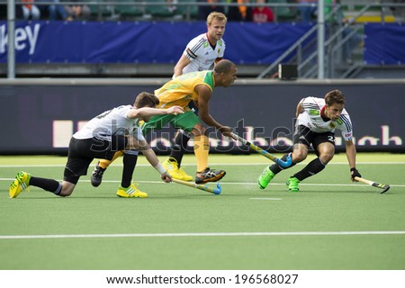 THE HAGUE, NETHERLANDS - JUNE 1: South African Hockey Player Julian HykesIs being stopped by two German defenders during the World Cup Hockey. GER-RSA 4-0