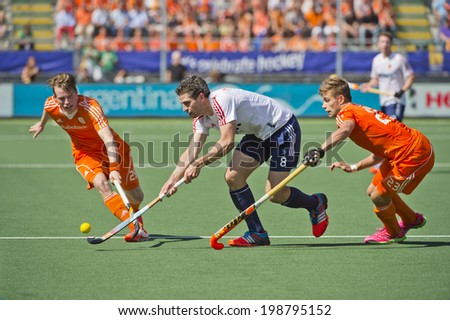 THE HAGUE, NETHERLANDS - JUNE 13: Dutch players Van Ass and De Wijn blocking England striker Simon Mantell during the semi-finals of the world championships hockey 2014. NED wins wity 2-1
