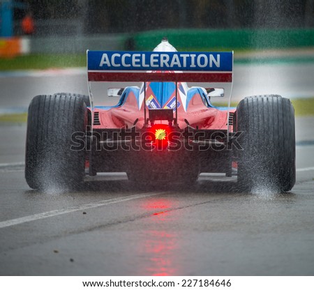 ASSEN, NETHERLANDS - OCTOBER 19, 2014: Formula A1 car with rain tires leaving a spray of water behind when leaving the pits lane during a wet race