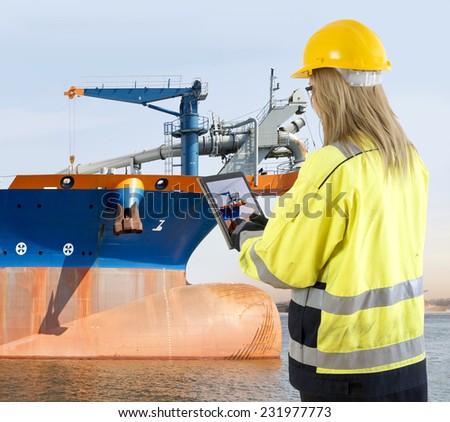Female quality assurance manager takinga picture of a dredging vessel with her tablet, looking for specific details during an inspection round