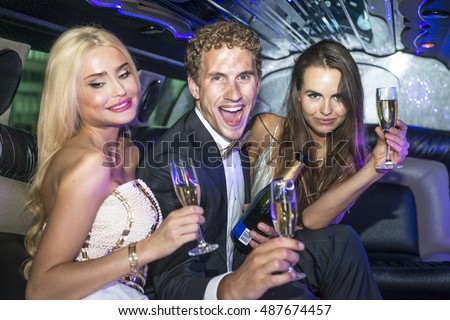 Rich and Famous young people drinking champagne and partying in a luxurious limousine