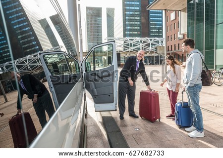 Professional cab driver and passengers with luggage by van at airport