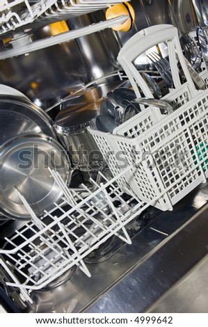 The interior of a dishwasher, with pots, pans, dish ware and cutlery.