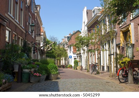 A quaint back alley in the center of Haarlem, the Netherlands, full of flowers and bicycles. As if time has come to a standstill.