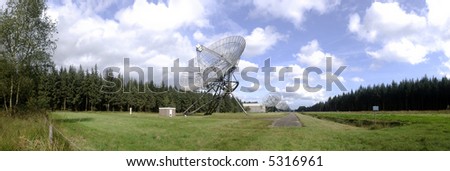 A neatly aligned row of radio telescopes, continuously scanning the universe near the second world war monument of Westerbork, the Netherlands