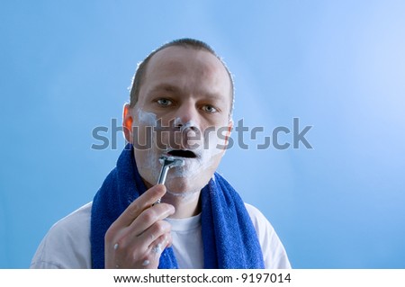 a middle aged man dressed in a white t-shirt, shaving himself