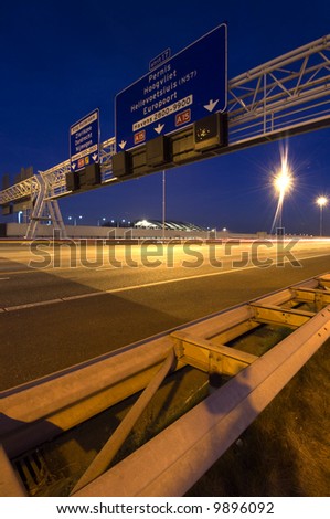 Steel structures, supporting traffic signs and direction information systems above a motorway at night