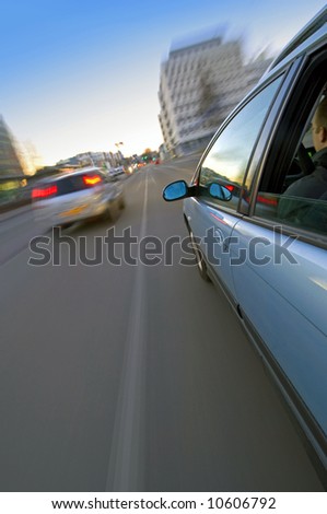 An exterior view on a car driving at saunset in an urban setting